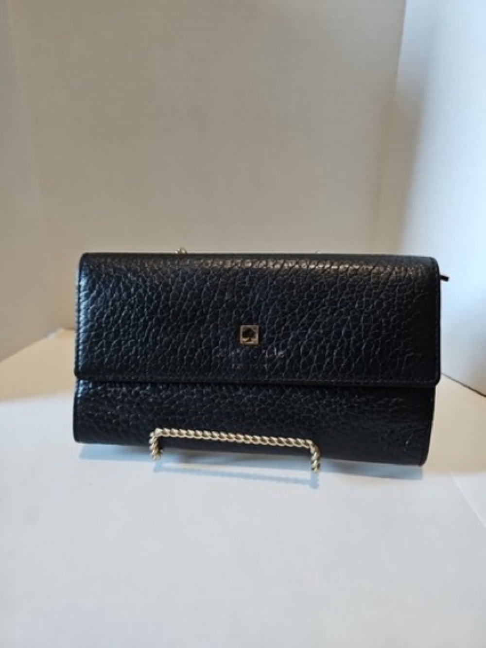 Kate Spade pebbled leather trifold wallet with a gold-tone logo emblem